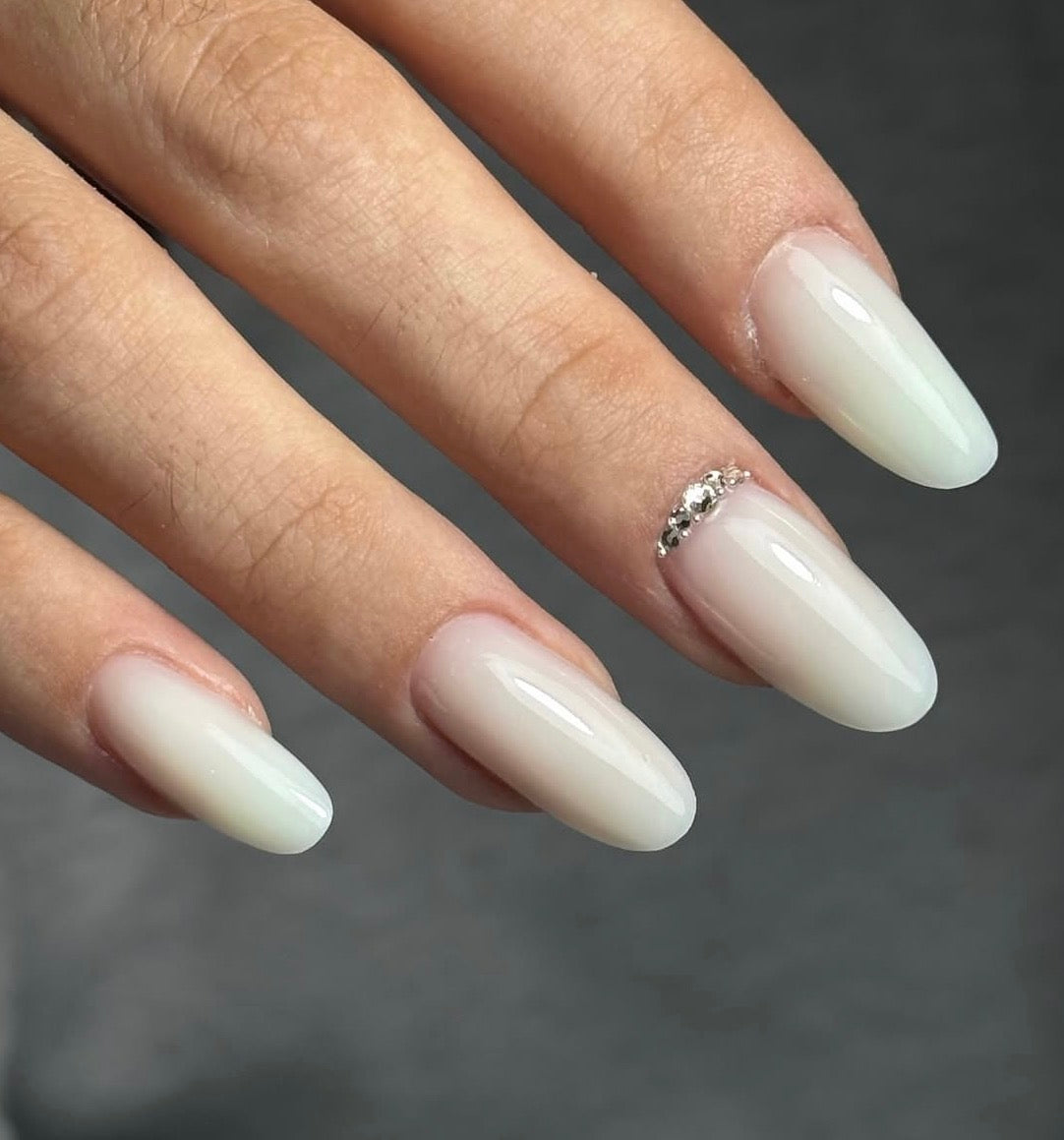 unghie forma mandorla bianco latte con brillantini nel giro cuticole